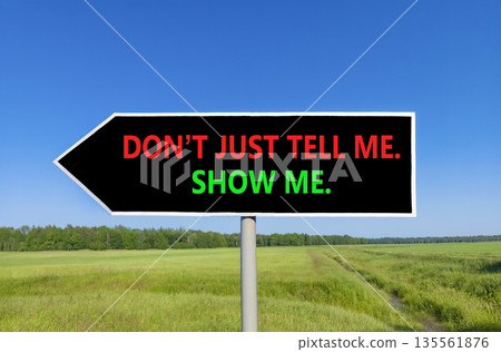 Tell or show symbol. Concept words Do not just tell me, show me beautiful black road sign. Beautiful blue sky green field background. Business tell or show concept. Copy space. Tell or show symbol. Concept words Do not just tell me, show me beautiful black road sign. Beautiful blue sky green field background. Business tell or show concept. Copy space. 135561876