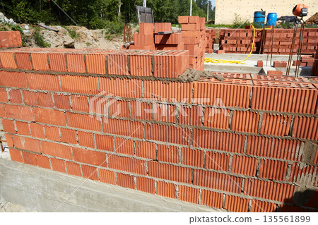 Constructed wall made of red clay bricks is being laid in a pattern. Constructed wall made of red clay bricks is being laid in a pattern. 135561899