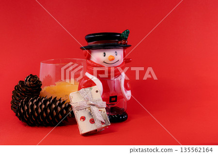 Festive Snowman and Pine Cones on Red Christmas Background Festive Snowman and Pine Cones on Red Christmas Background 135562164