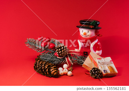 Festive Snowman and Pine Cones on Red Christmas Background Festive Snowman and Pine Cones on Red Christmas Background 135562181
