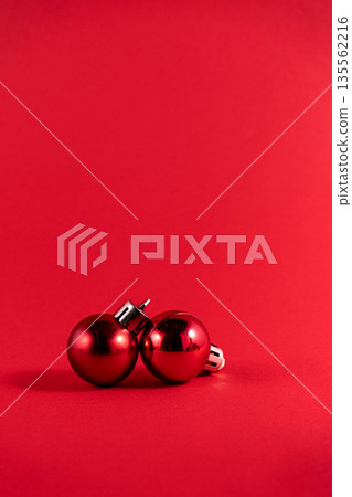 Minimalist Christmas Composition with Two Red Ornaments on Red Background Minimalist Christmas Composition with Two Red Ornaments on Red Background 135562216