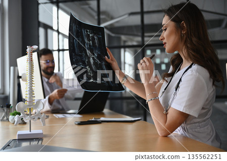 Multiple scans on x-ray. Two doctors are in the office 135562251