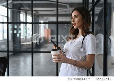 Coffee break, with cup. Woman doctor is in the office Coffee break, with cup. Woman doctor is in the office 135562319