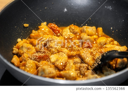 Sweet and sour chicken in frying pan 135562366