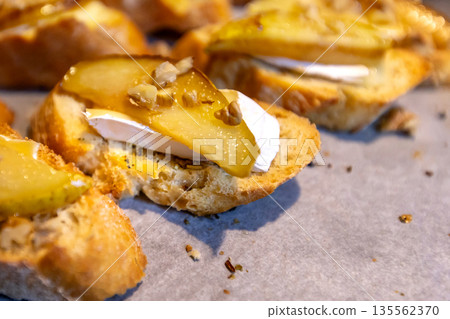 Pear bruschetta with white cheese and walnuts Pear bruschetta with white cheese and walnuts 135562370