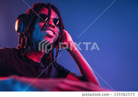 DJ in club. African American guy is studio with neon lighting 135562573