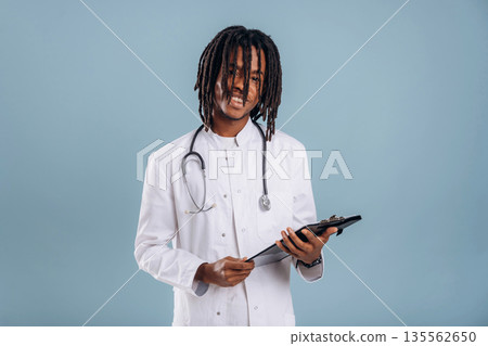 Doctor with stethoscope. Black man is in the studio against soft background Doctor with stethoscope. Black man is in the studio against soft background 135562650