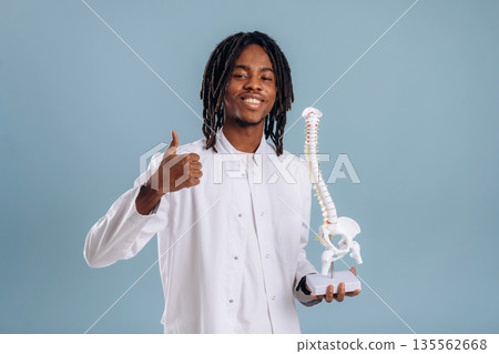 Education concept, human spine model. Black man is in the studio against soft background 135562668