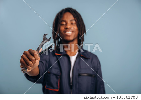 Plumber with tools, wrench. Black man is in the studio against soft background 135562708
