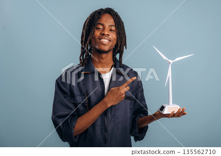 Wind turbine model in hand. Black man is in the studio against soft background 135562710