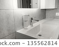Modern bathroom setup in a minimalist interior, faucet and automatic, touchless soap dispenser. New 2026 trend Cloud Dancer color. 135562814