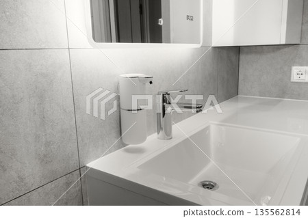 Modern bathroom setup in a minimalist interior, faucet and automatic, touchless soap dispenser. New 2026 trend Cloud Dancer color. Modern bathroom setup in a minimalist interior, faucet and automatic, touchless soap dispenser. New 2026 trend Cloud Dancer color. 135562814