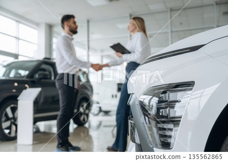 Man and woman are in the car dealership Man and woman are in the car dealership 135562865