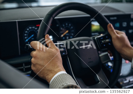 By steering wheel. Man is sitting in car, detailed view By steering wheel. Man is sitting in car, detailed view 135562927