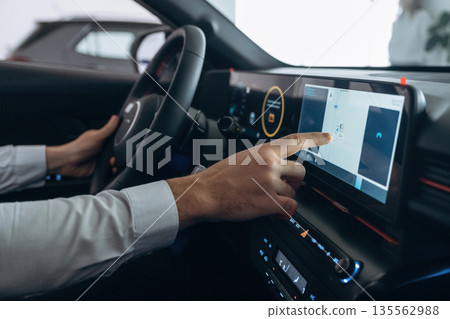 Side view. Man is sitting in car, detailed view Side view. Man is sitting in car, detailed view 135562988