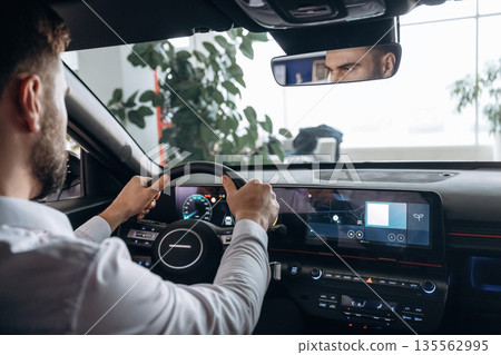 View from behind. Man is sitting in car, detailed view View from behind. Man is sitting in car, detailed view 135562995