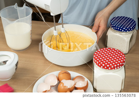 Close-up of the Baking Process. Preparing Dough with a Mixer on a Kitchen Countertop. 135563078
