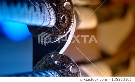 Detailed view of a traditional samurai sword guard with dragon motif and cinematic lighting Detailed view of a traditional samurai sword guard with dragon motif and cinematic lighting 135563105