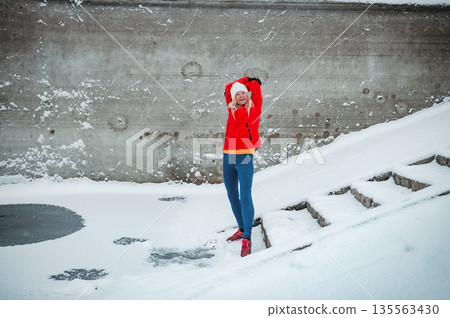 Winter workout for senior woman in snowy city. Winter workout for senior woman in snowy city. 135563430