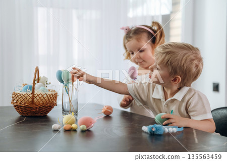 Colorful eggs for Easter. Kids are preparing bakery at home Colorful eggs for Easter. Kids are preparing bakery at home 135563459