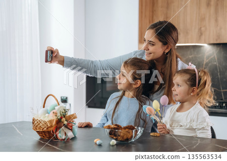 Making selfie. Mother with her little daughters preparing bakery Making selfie. Mother with her little daughters preparing bakery 135563534