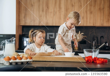 Sister and brother. Kids are preparing bakery at home Sister and brother. Kids are preparing bakery at home 135563590