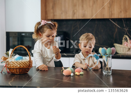 Colorful eggs for Easter. Kids are preparing bakery at home Colorful eggs for Easter. Kids are preparing bakery at home 135563626