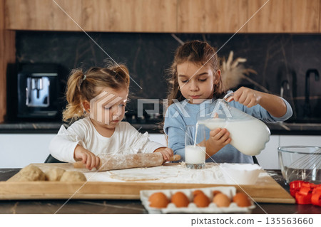 Sweet product. Two little girls are preparing bakery at home Sweet product. Two little girls are preparing bakery at home 135563660