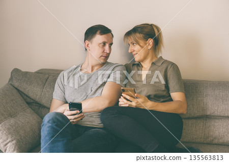 Man and woman holding smartphones Man and woman holding smartphones 135563813