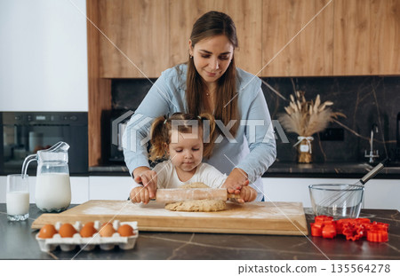 Bunch of eggs. Mother and daughter are cooking on the kitchen 135564278
