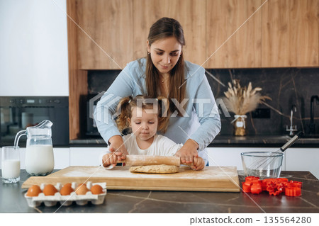 Bunch of eggs. Mother and daughter are cooking on the kitchen Bunch of eggs. Mother and daughter are cooking on the kitchen 135564280