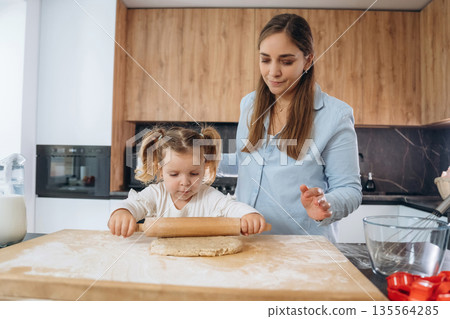 Two people. Mother and daughter are cooking on the kitchen Two people. Mother and daughter are cooking on the kitchen 135564285