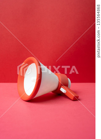 A red megaphone on a red background. Advertising and propaganda. Mass communication symbol, influence and persuasion tools. Marketing pressure, political messaging and public opinion shaping. A red megaphone on a red background. Advertising and propaganda. Mass communication symbol, influence and persuasion tools. Marketing pressure, political messaging and public opinion shaping. 135564868