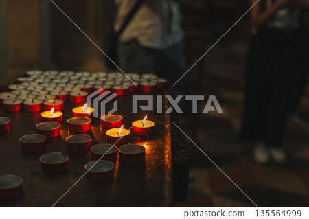 Burning candles in an old church. Selective focus. Burning candles in an old church. Selective focus. 135564999