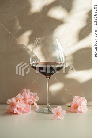 Red Wine Glasses with Sakura Cherry Blossoms. Elegant Spring Still Life Red Wine Glasses with Sakura Cherry Blossoms. Elegant Spring Still Life 135565101