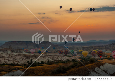 Hot air balloon flying over rocky landscape at sunrise in Cappadocia. Turkey 135565502