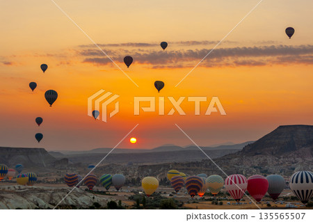 Hot air balloon flying over rocky landscape at sunrise in Cappadocia. Turkey 135565507