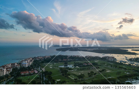 Sunrise aerial view of Fisher island, Miami. Miami beach with waterfront architecture. Miami residential building, Florida. Fisher island. Travel destination. Fisher island sunrise view Sunrise aerial view of Fisher island, Miami. Miami beach with waterfront architecture. Miami residential building, Florida. Fisher island. Travel destination. Fisher island sunrise view 135565603