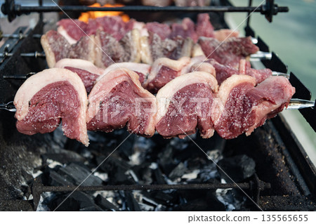 Beef meat BBQ grill. Steak rotisserie at steakhouse grill. Street food. Grilled roast beef. Grilled picanha. Brazilian BBQ. Family barbecue. Picanha barbecue roasted over hot coals. Grilling and BBQ 135565655