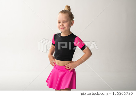 Child with hearing implant in pink skirt smiling confidently, copy space. Connection of technology, self-expression, and artistic therapy in inclusive children performance. Child with hearing implant in pink skirt smiling confidently, copy space. Connection of technology, self-expression, and artistic therapy in inclusive children performance. 135565780