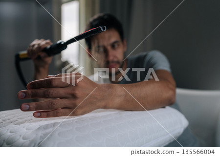 Man enjoying cleaning routine, smiling and playfully interacting with steam from home cleaner, finding joy in daily chores and domestic tasks. Concept of playful household chores and hygiene. 135566004