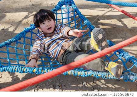 child playing on playground equipment in the park 135566673