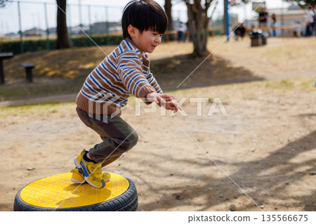 child playing on playground equipment in the park 135566675