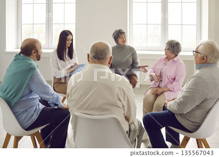 Group of senior people sharing and discussing their problems during meeting with therapist Group of senior people sharing and discussing their problems during meeting with therapist 135567043