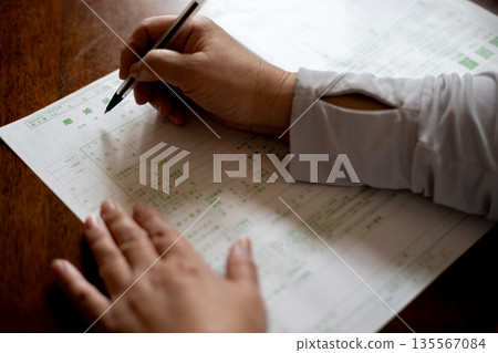 一位女士正準備用原子筆填寫離婚文件。 135567084