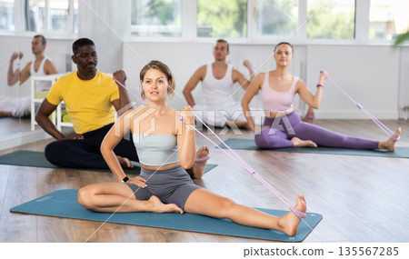 Group of of active people of different nationalities exercising their arm muscles using resistance bands Group of of active people of different nationalities exercising their arm muscles using resistance bands 135567285