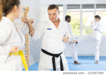 Adult man and adult woman train judo techniques Adult man and adult woman train judo techniques 135567300