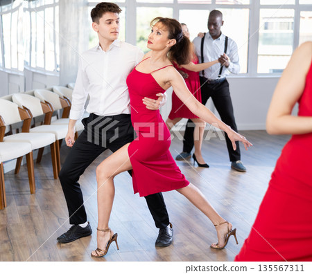 Young man and woman dancing waltz in couple during lesson at studio 135567311