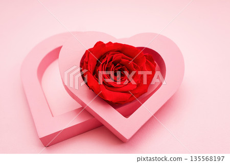 Red rose inside pink hearts over pastel background 135568197