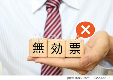 A man holds a wooden block indicating an invalid vote. A man holds a wooden block indicating an invalid vote. 135568492
